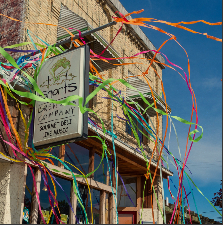 Short's Brewing Company Pub face covered with multicolored crepe paper blowing in the wind.