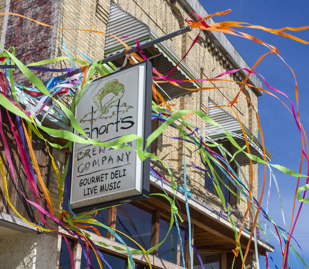 Short's Brewing company sign covered with colorful rainbow streamers