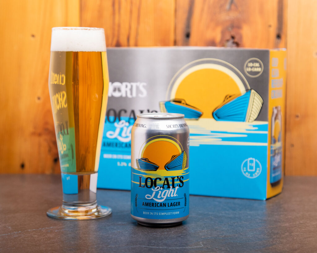 Photo of a can of Local's Light lager and a tall pint glass