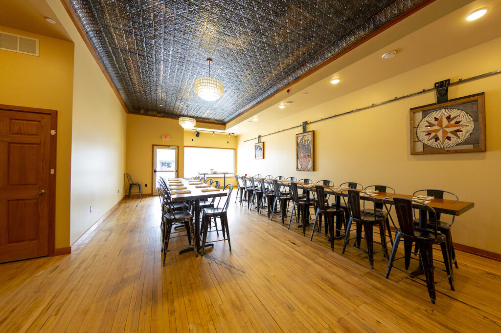 Interior photo of The South End private event space filled with warm wood, tin ceilings and mosaics