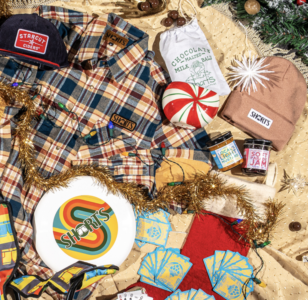 a variety of items including hats, shirts, and playing cards, arranged in a pleasing way with holiday decor
